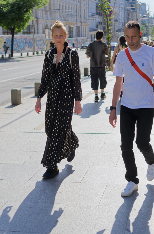 29 - A couple walking down a sunlit city street